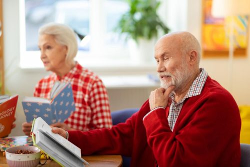 focused-reading-thoughtful-senior-man-touching-his-chin-while-reading-interesting-book-500x333