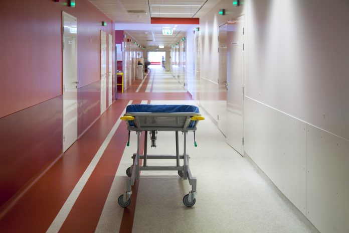 Tartu,Estonia,Corridor and waiting areas of a modern hospital with seating, a trolley bed wih blue mattress struttura ospedaliera